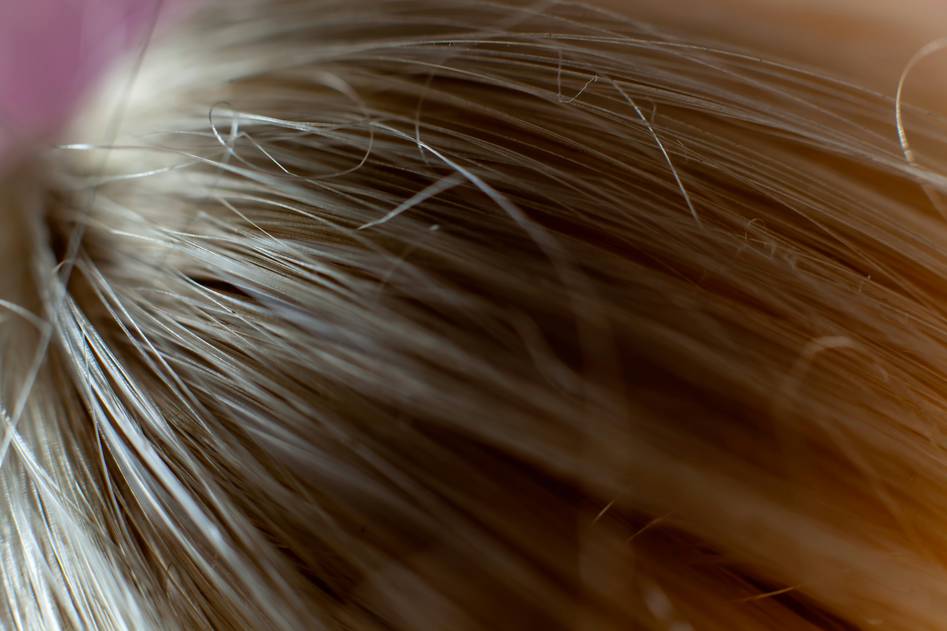 Collection of organic hair serum bottles arranged on a soft linen cloth