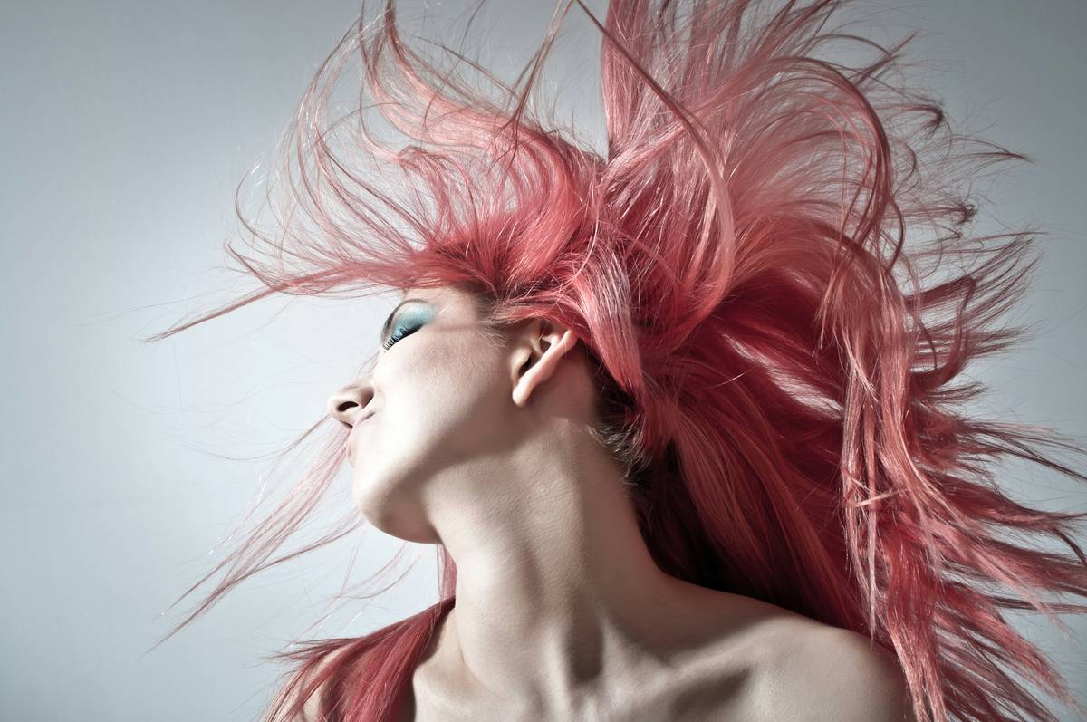 woman applying hair smoothing serum to damp hair correctly